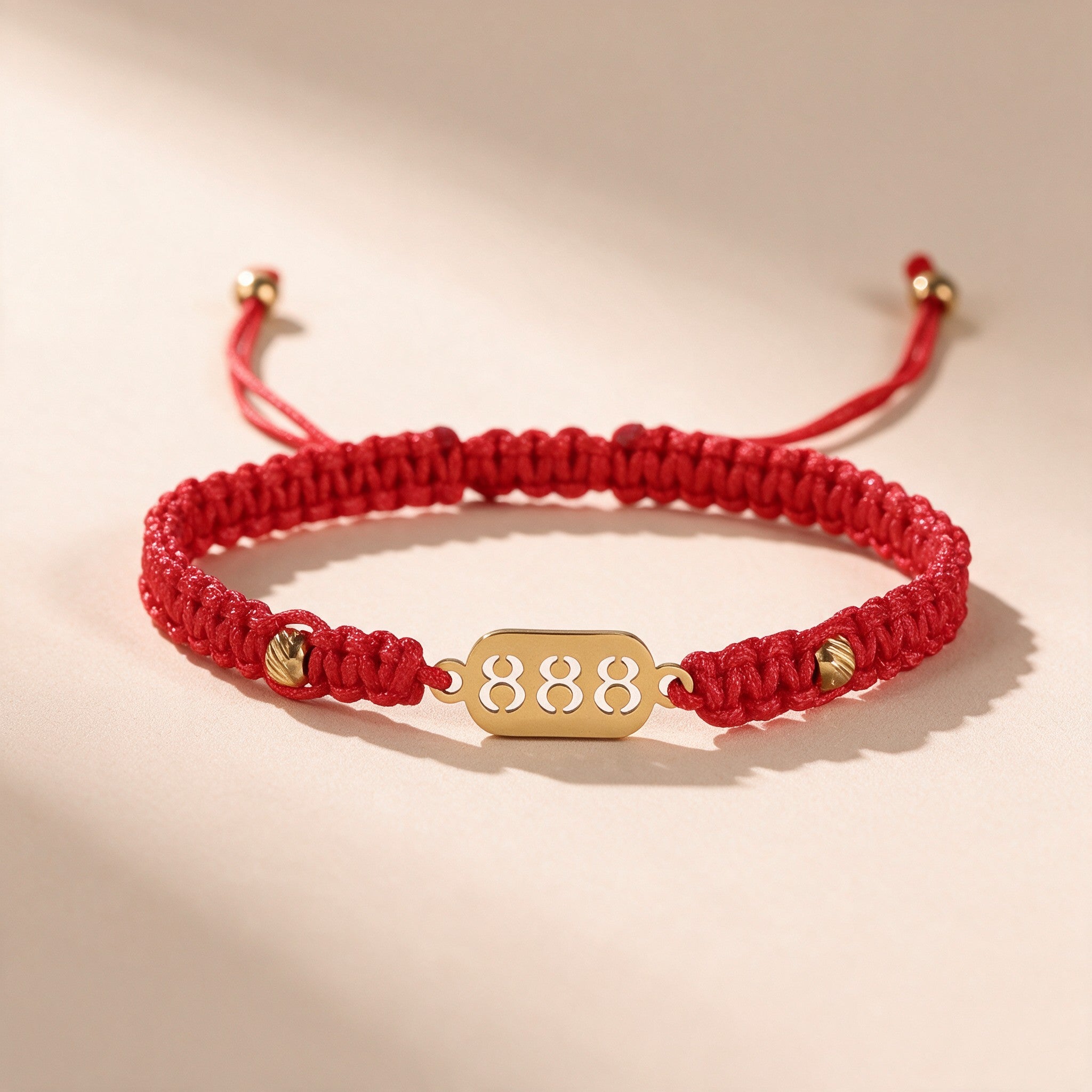 888 Angel Number Bracelet full view: braided red string, gold-tone 888 charm plate and adjustable slide knot